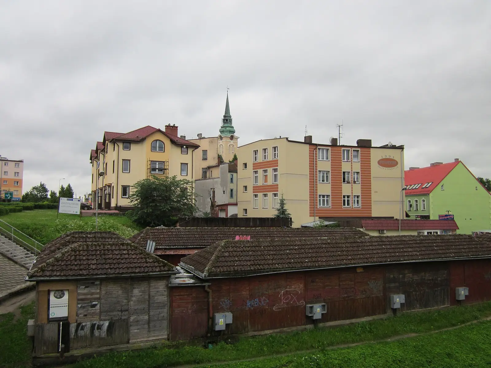 Widok z mostu na rzece Studnicy na kamienice Miastka, w oddali wieża kościoła